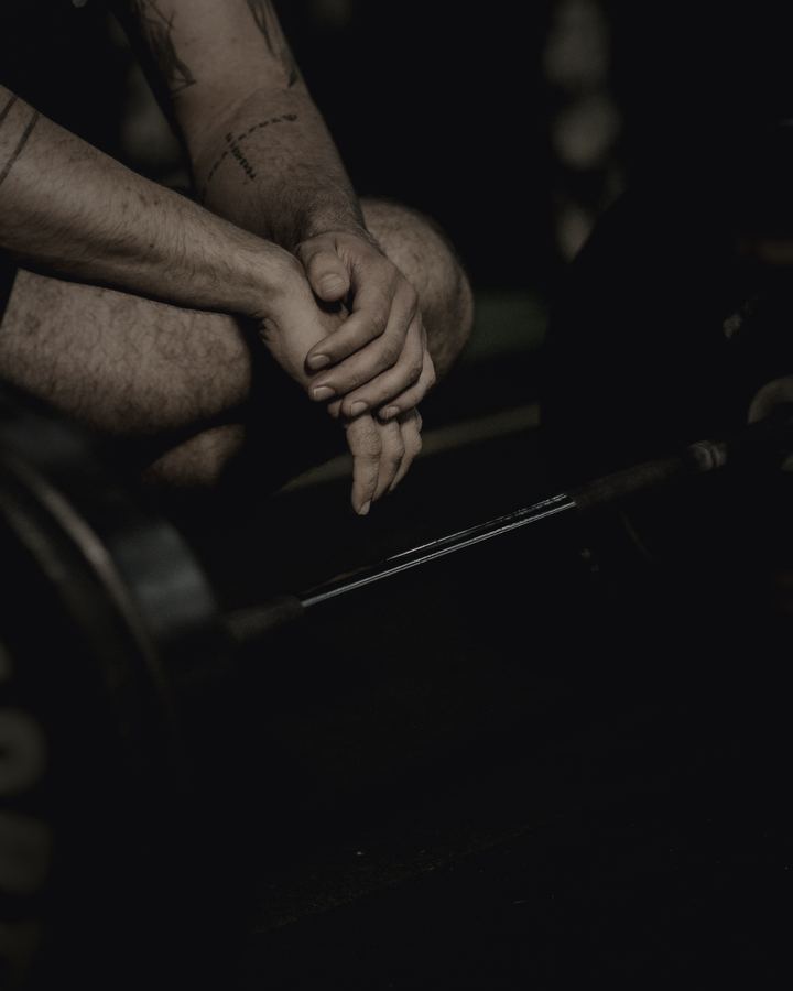 A man resting between sets beside a loaded bar